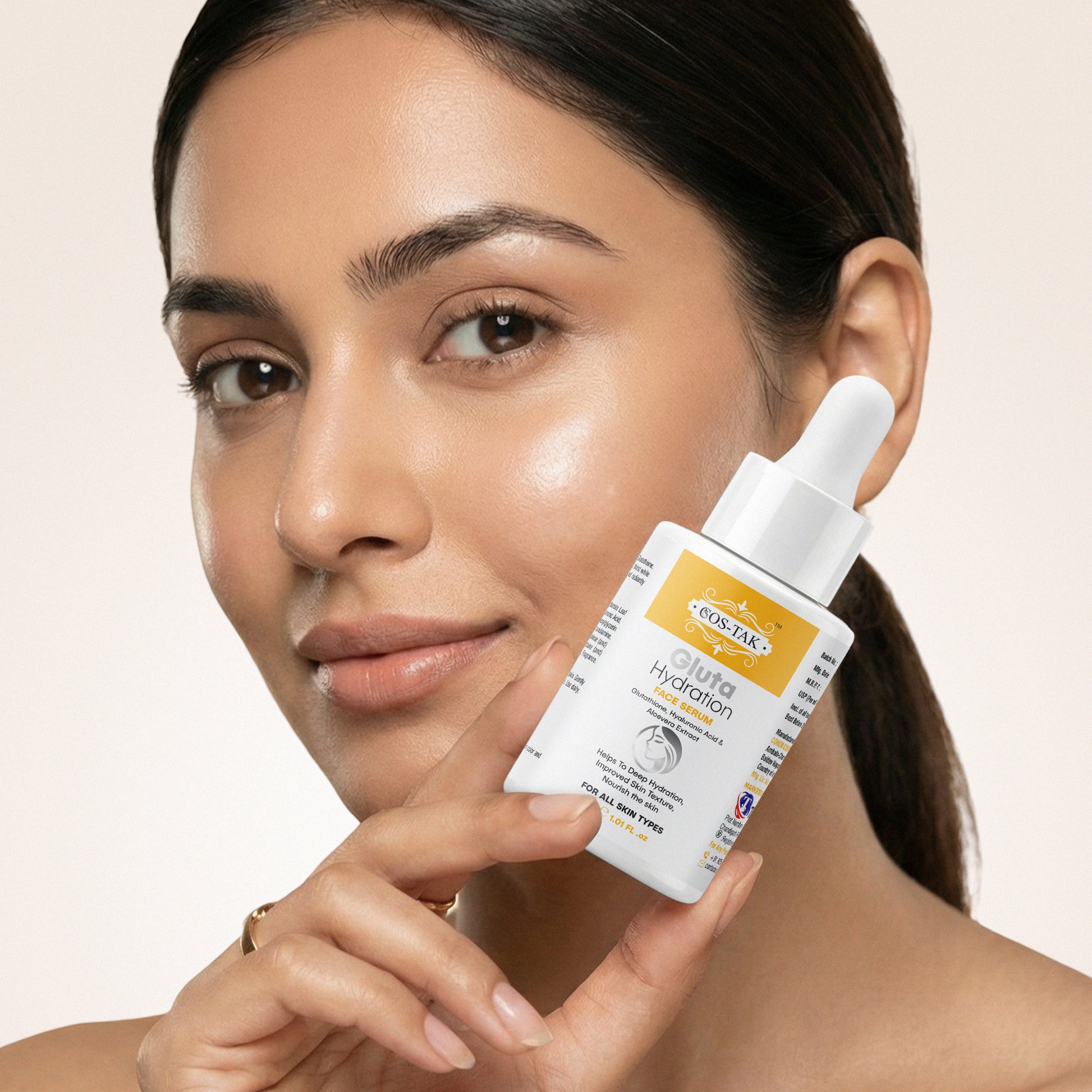 Costak Woman holding a skincare product with a beige background