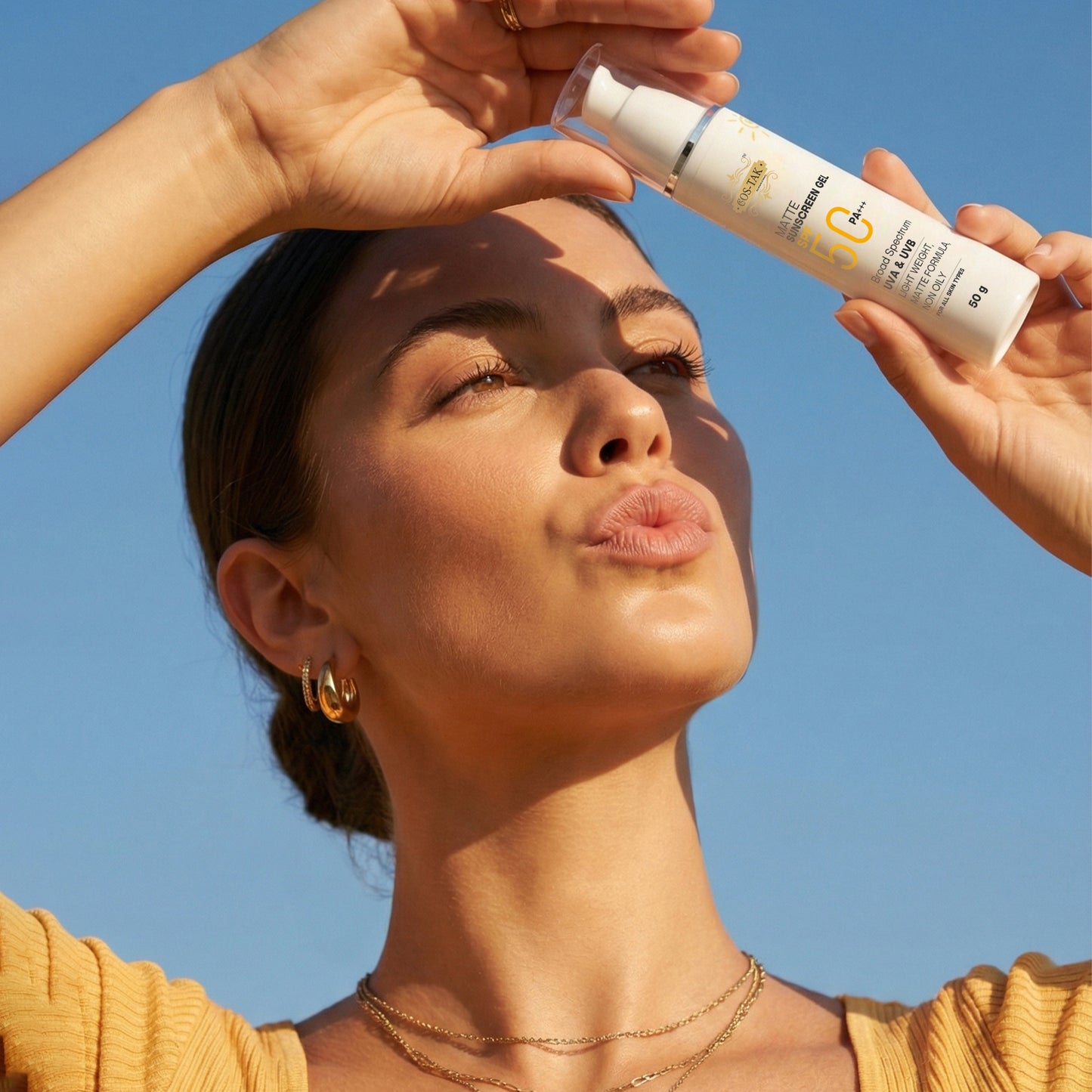 Costak Woman applying sunscreen to her face with a clear blue sky background